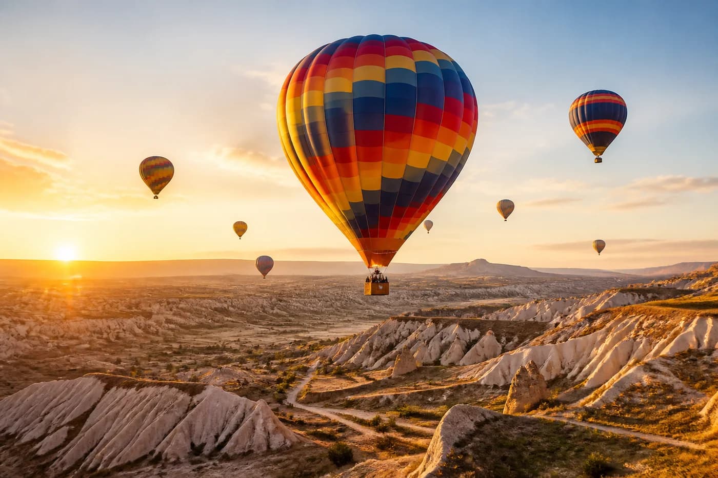 Hot air balloons over a desert valley at sunrise